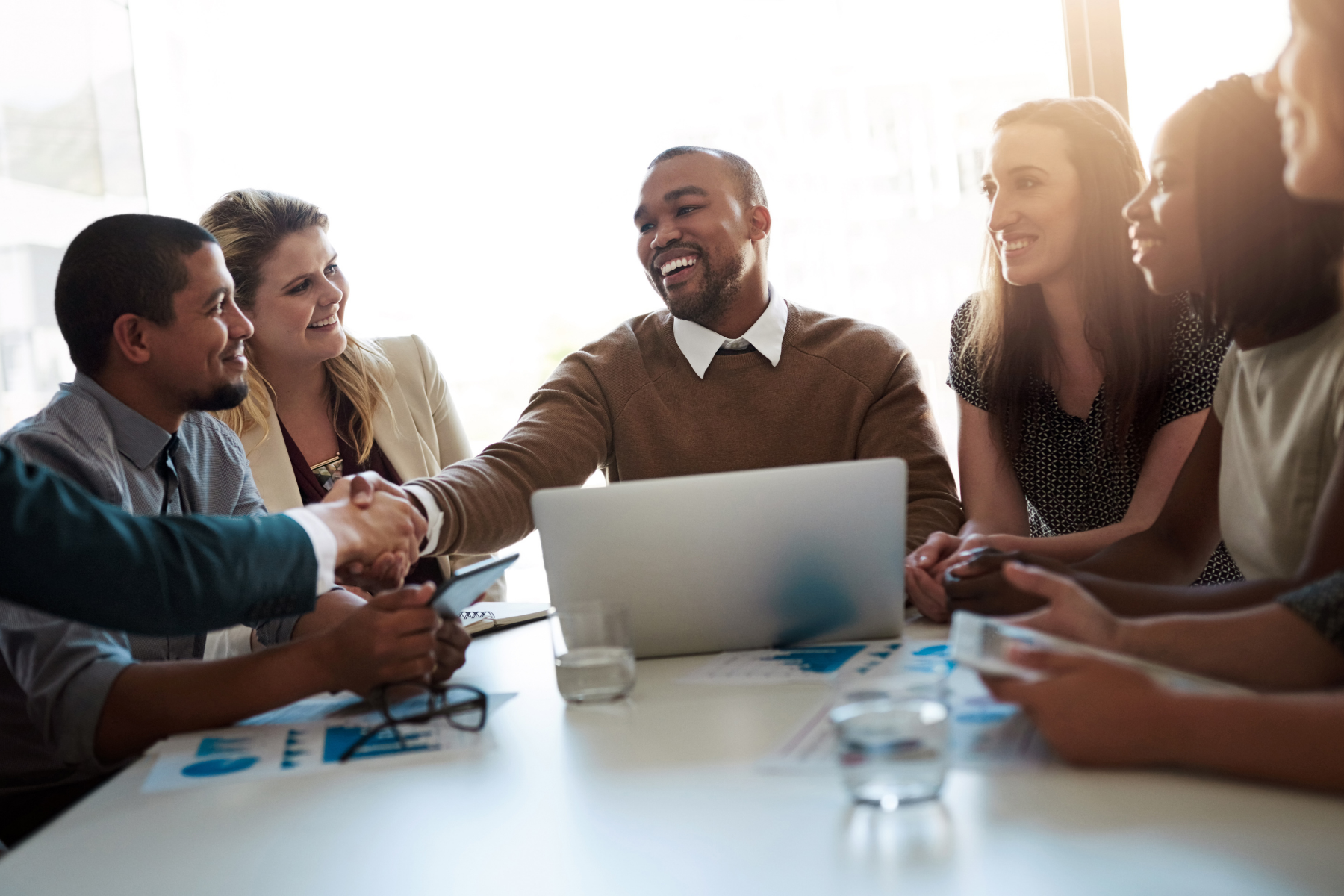 Parody stock photo of business team shaking hands, used to illustrate fake study about Small Pee Pee Big Dreams bumper sticker uniting America.