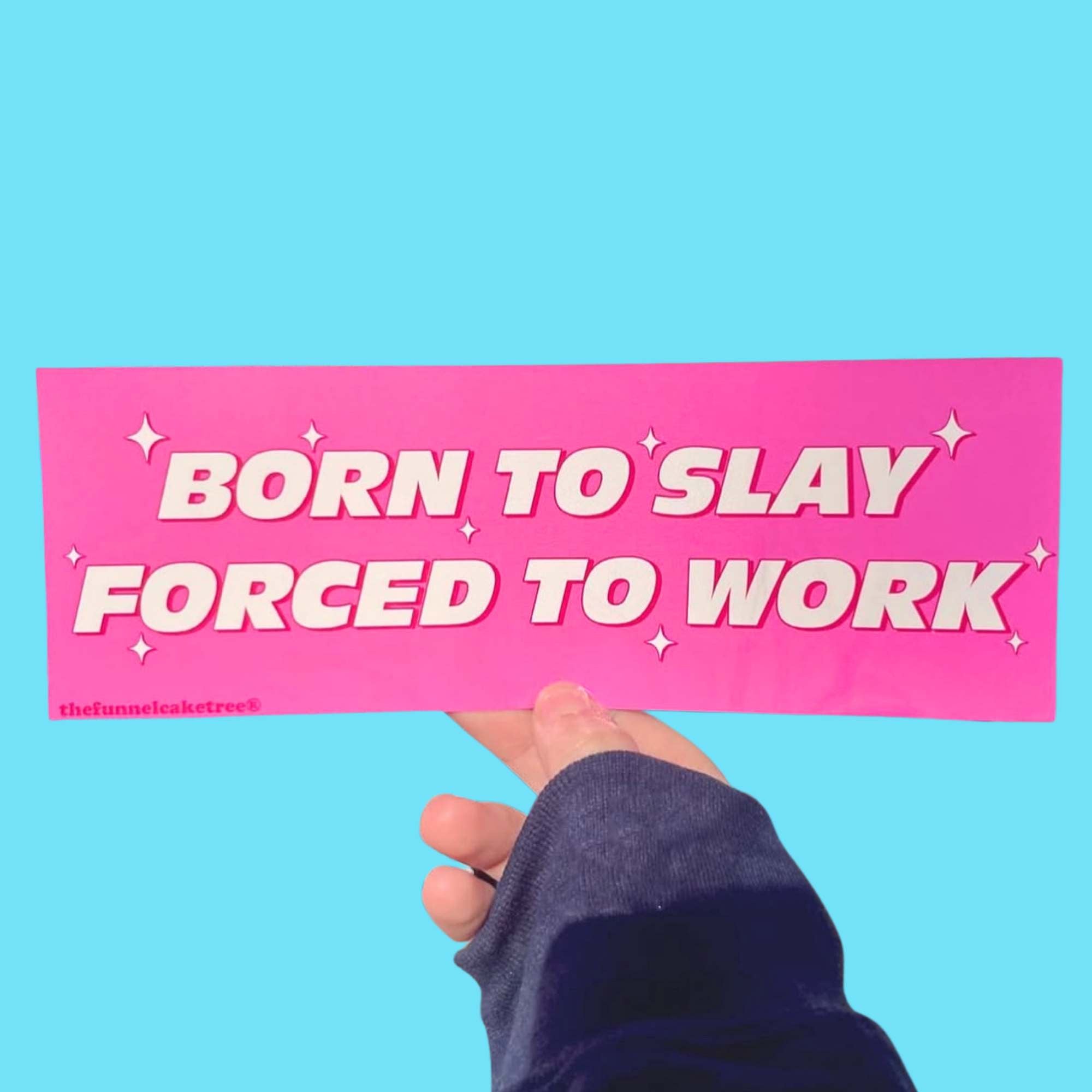 Glossy bright pink bumper sticker with bold white text reading “Born to Slay, Forced to Work” surrounded by small sparkles.