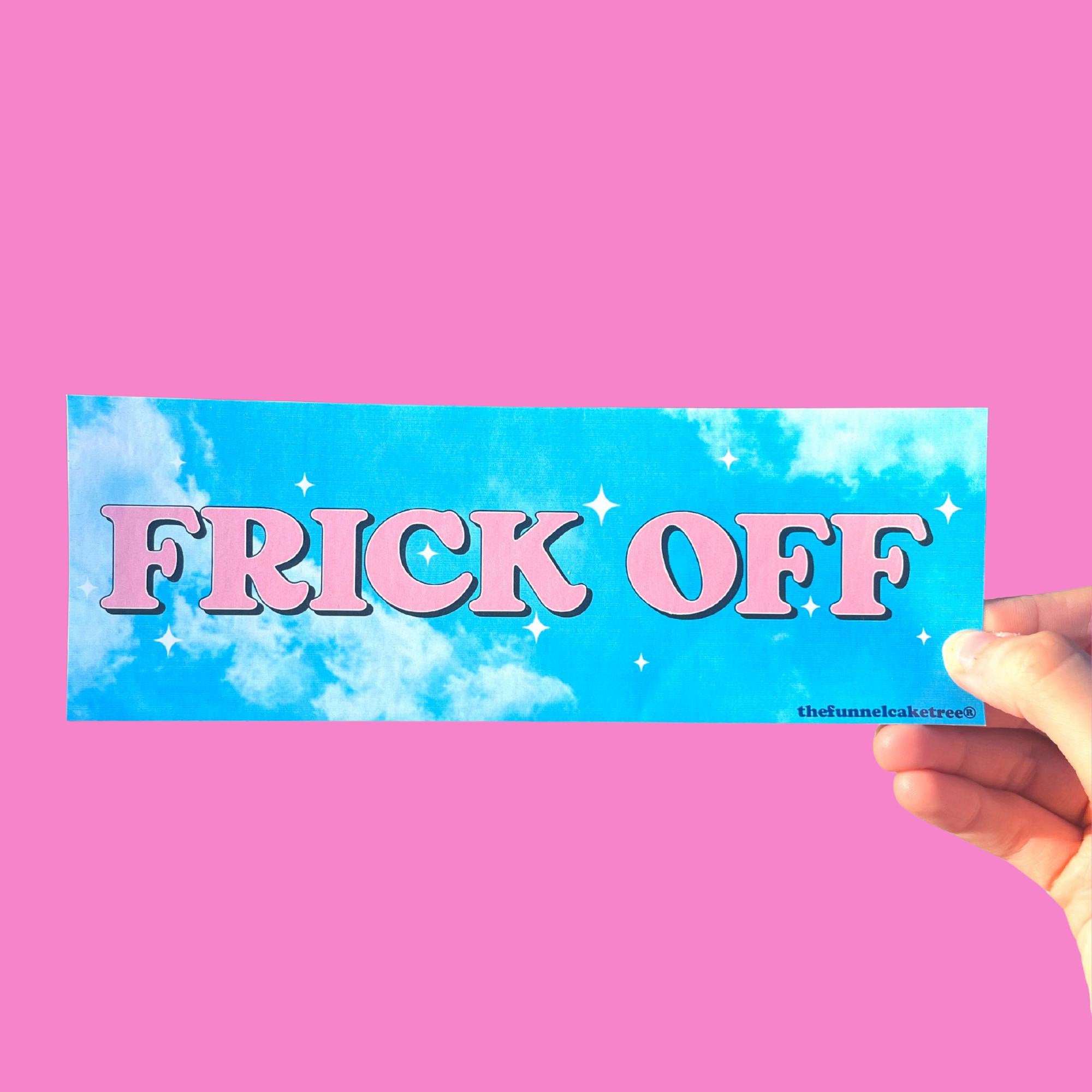  Glossy blue sky bumper sticker with white clouds, sparkles, and large pink text reading “FRICK OFF,” held against a pink background.