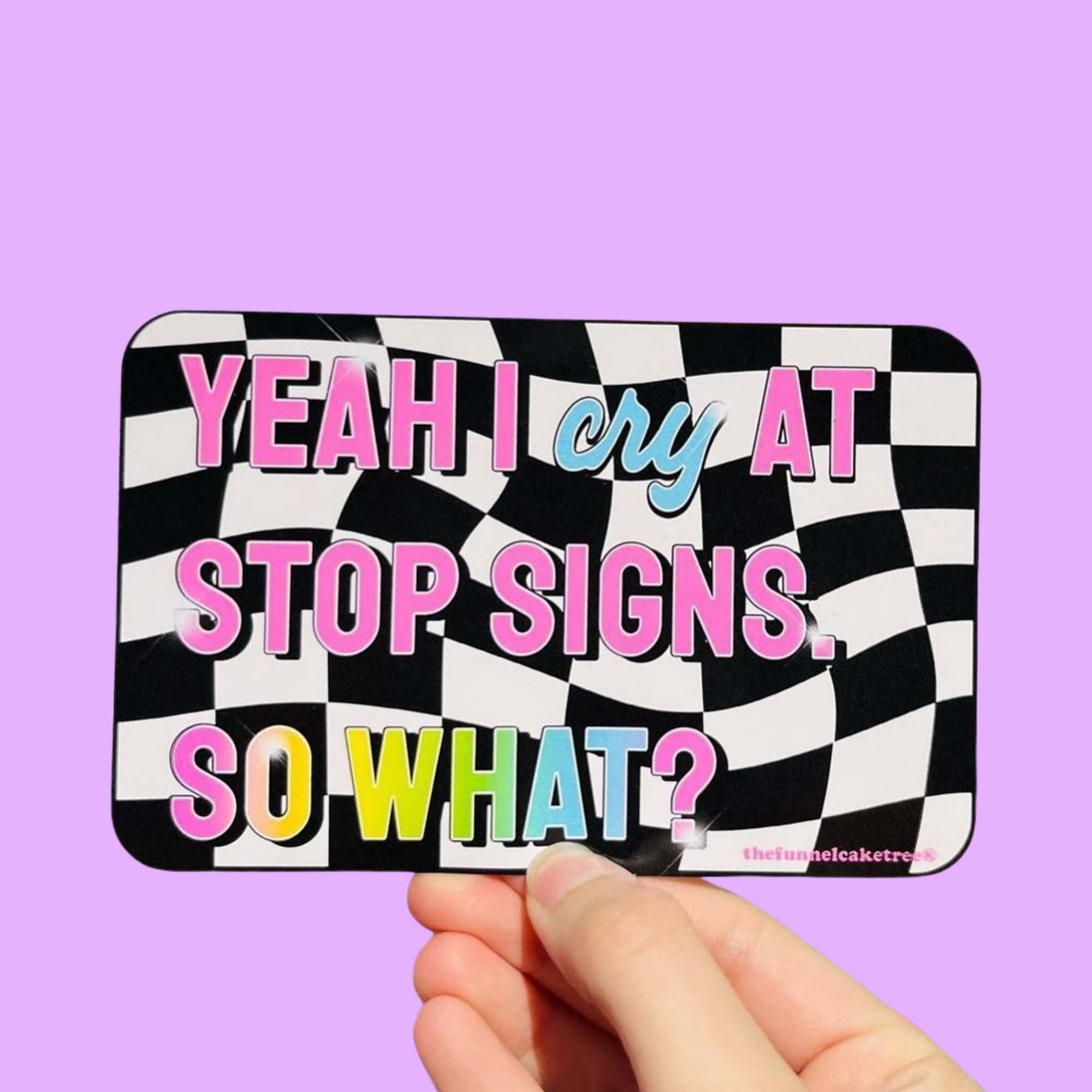  Glossy bumper sticker with black and white checkered background and colorful text reading “Yeah I cry at stop signs. So what?”