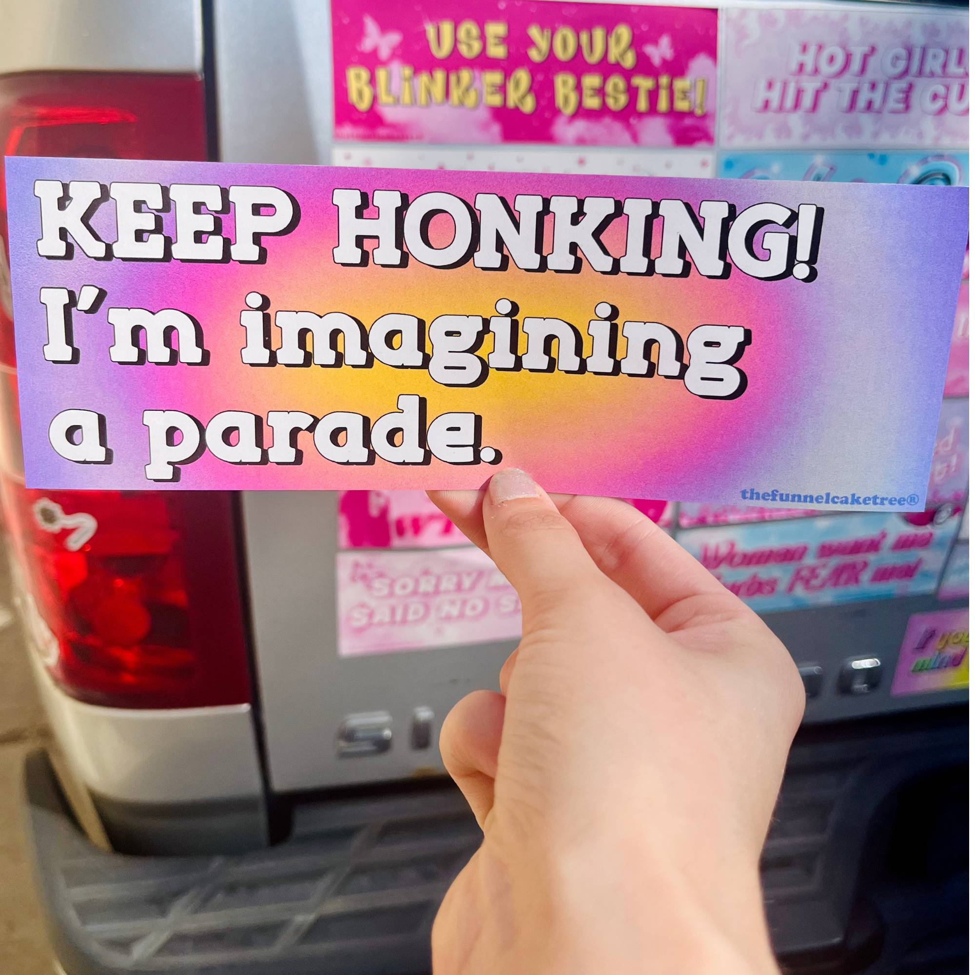  “Funny vinyl bumper sticker that says ‘Keep Honking Im imagining a parade’ — waterproof and UV-protected, perfect for cars.”
