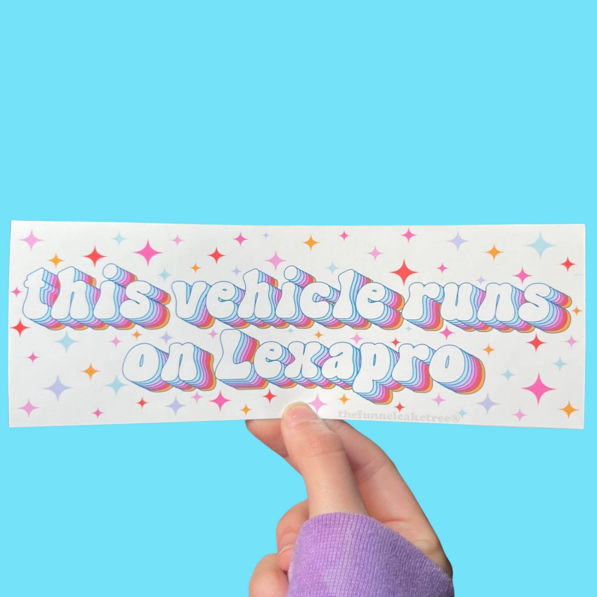  Glossy white bumper sticker with pastel text reading “This vehicle runs on Lexapro,” surrounded by colorful starburst accents.