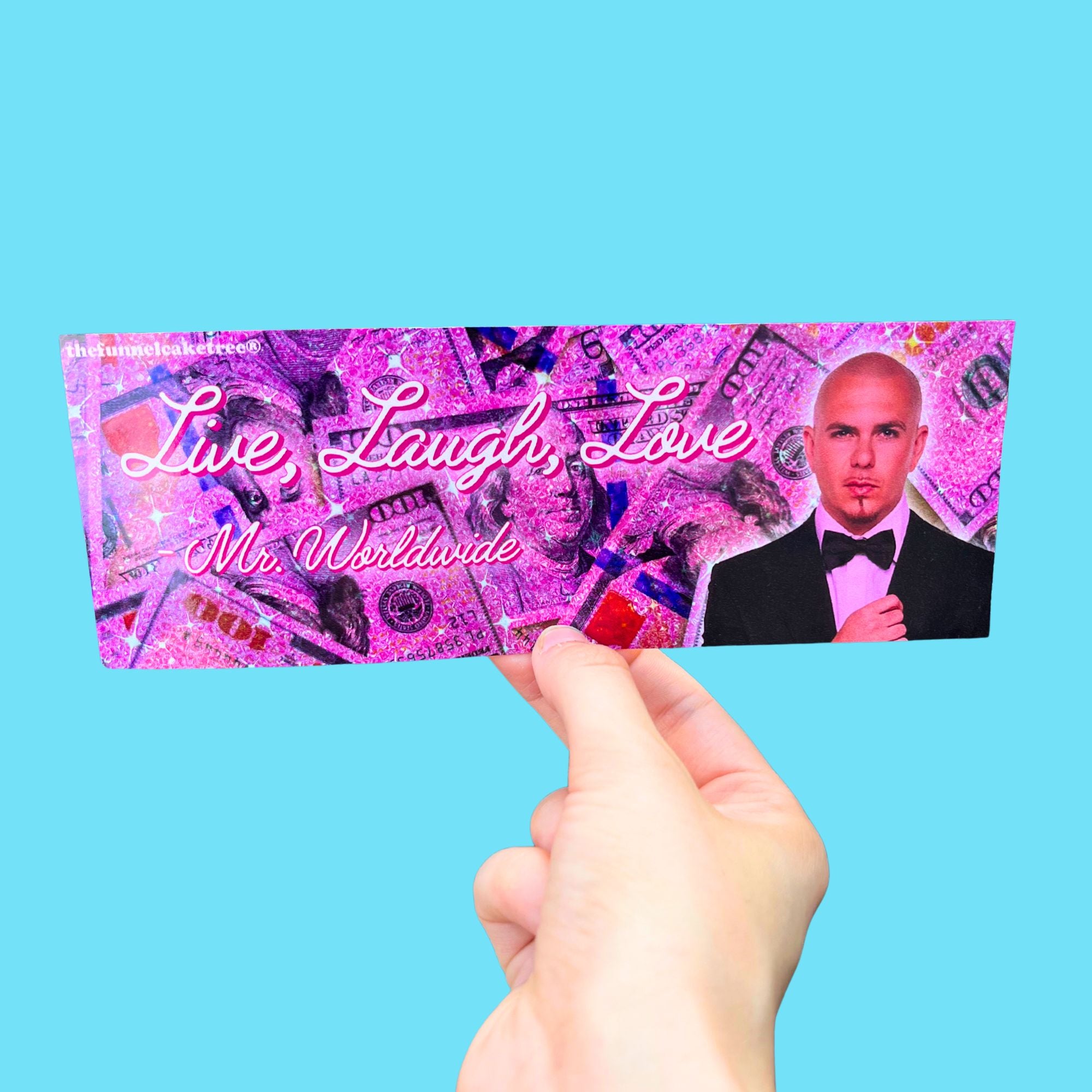 Hand holding a card with a person's face and 'Live, Laugh, Love Mr. Worldwide' text on a blue background