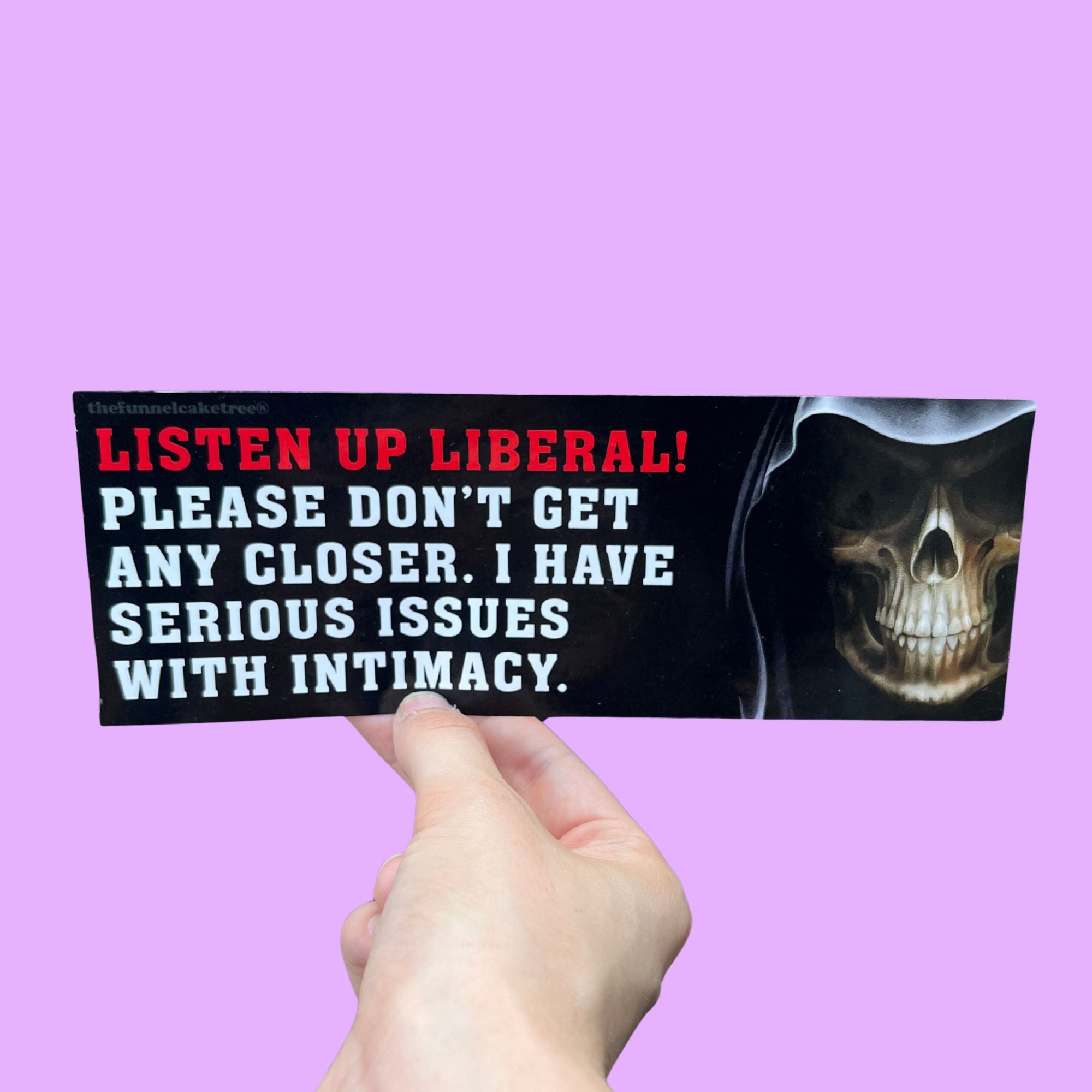 Glossy black bumper sticker with red and white text reading “LISTEN UP LIBERAL! PLEASE DON’T GET ANY CLOSER. I HAVE SERIOUS ISSUES WITH INTIMACY.” and an image of a grinning skeleton in a hood.