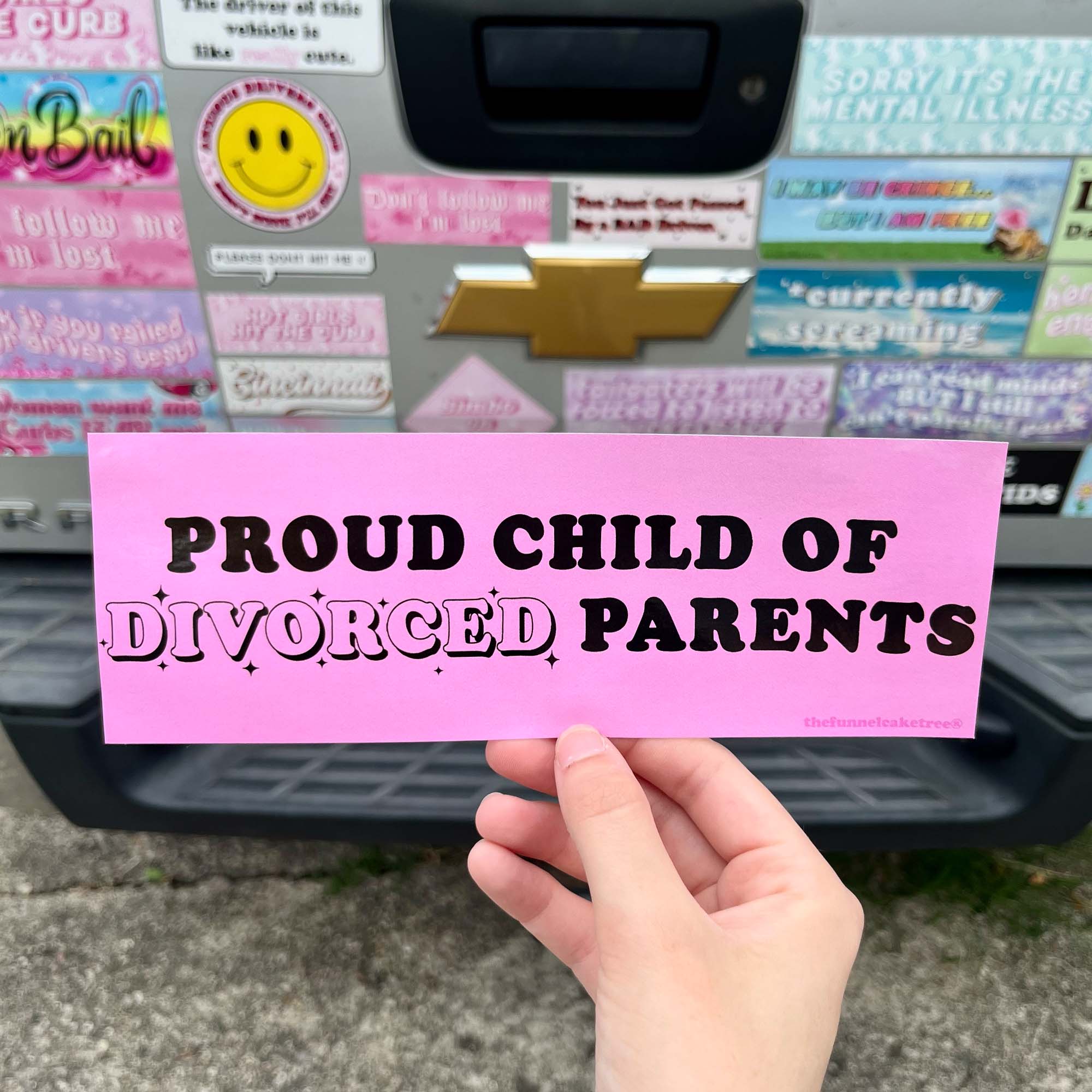 Funny vinyl bumper sticker in pink that says ‘Proud child of divorced parents’ in black text — waterproof and UV-protected, perfect for cars.