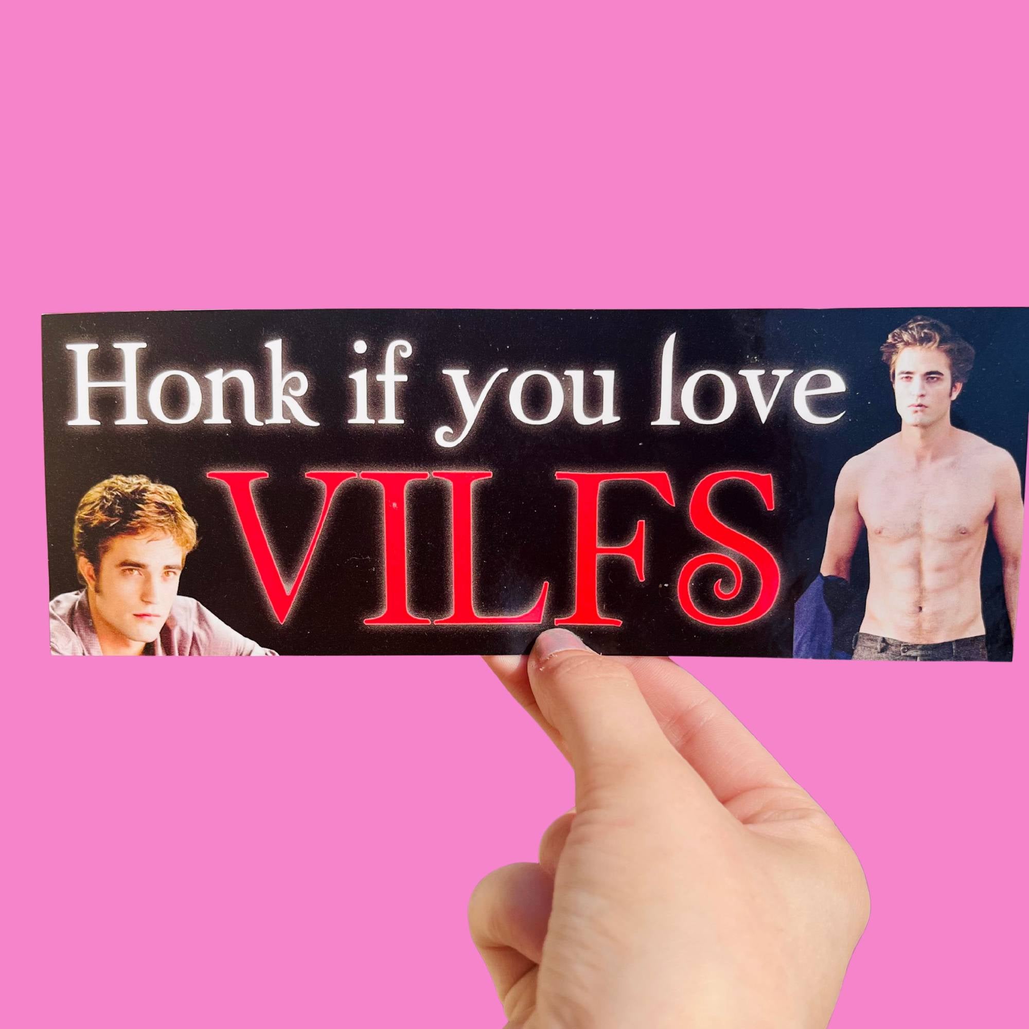 Glossy black bumper sticker with white and red text reading “Honk if you love VILFs,” featuring two images of a brooding vampire character.