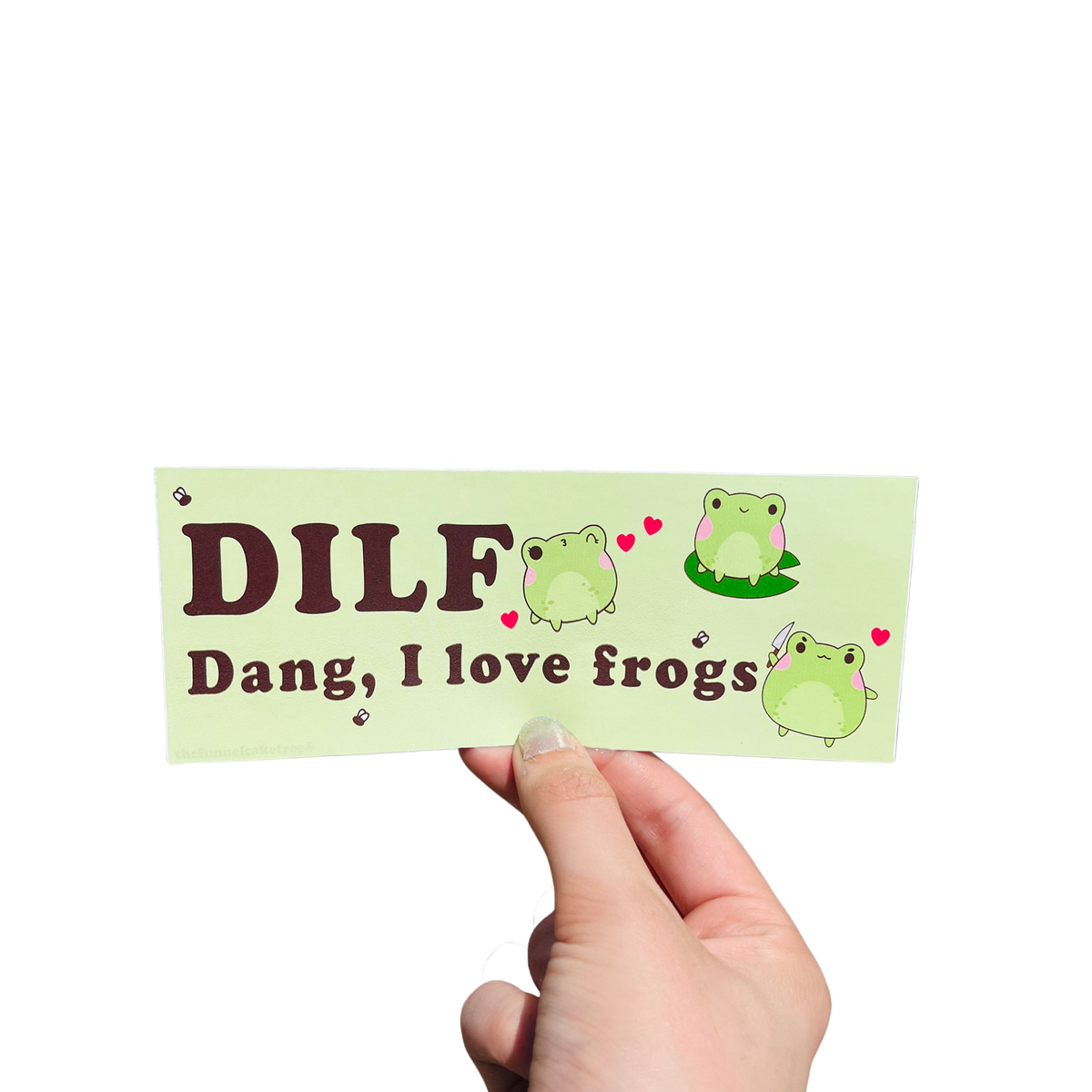 Hand holding a green mini bumper sticker reading 'DILF — Dang, I love frogs,' with cartoon frogs and hearts.
