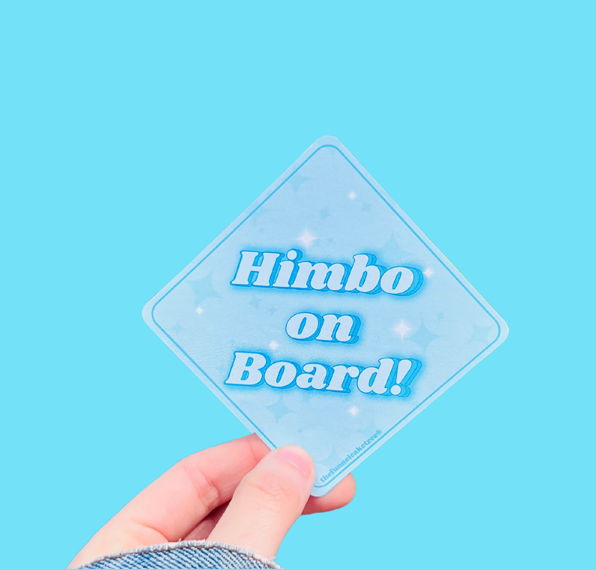 Hand holding a mini bumper sticker reading "himbo on board." On a solid teal background.