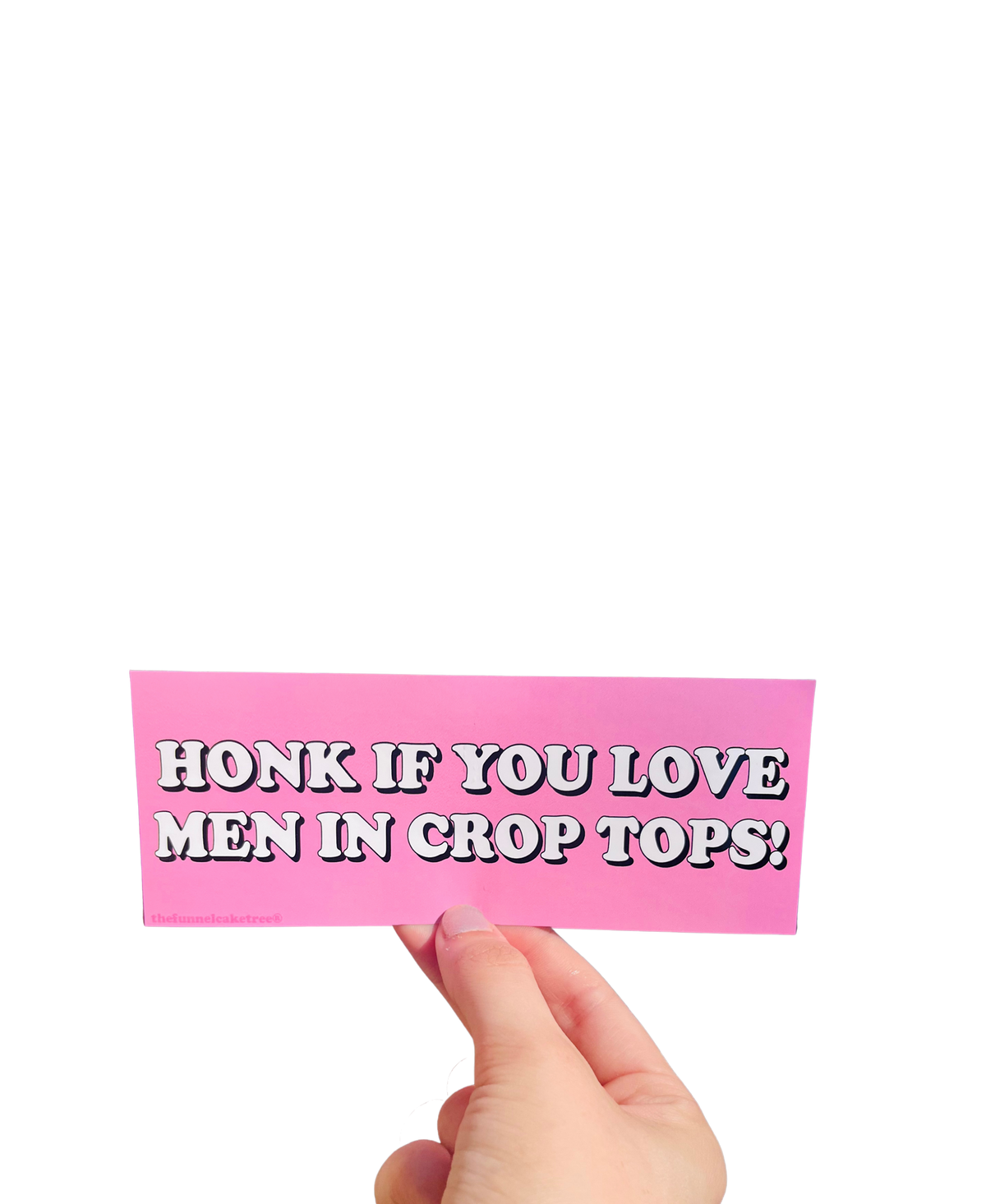 Hand holding a pink mini bumper sticker reading 'Honk if you love men in crop tops!' in white lettering.