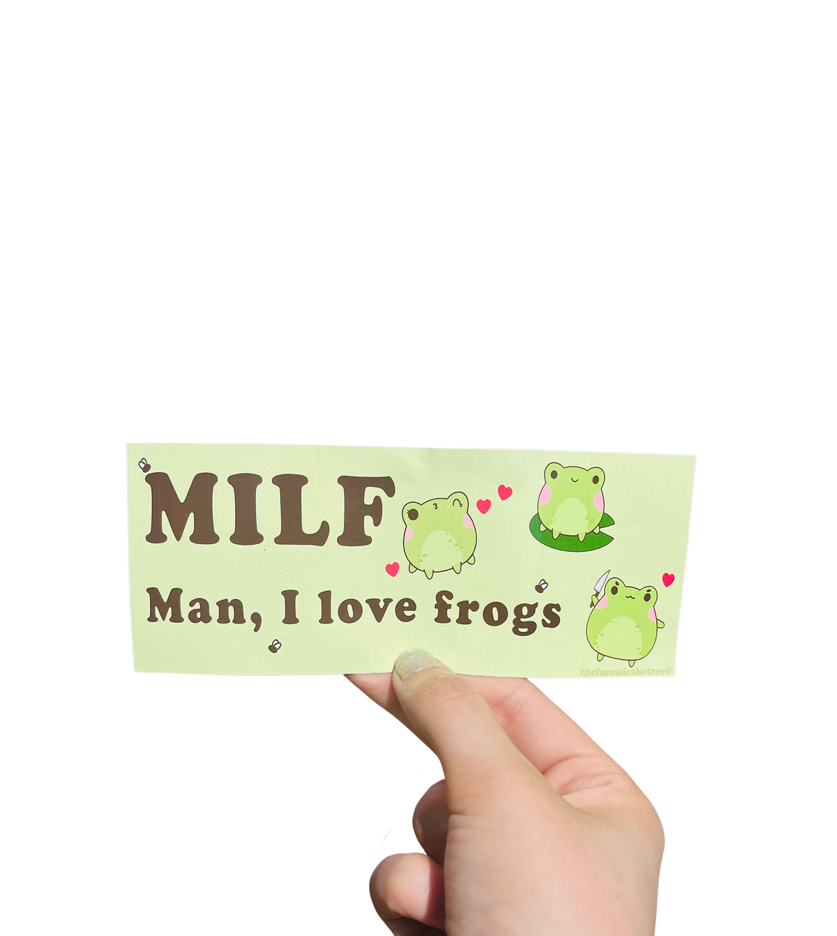 Hand holding a green mini bumper sticker reading 'MILF — Man, I love frogs' with cartoon frogs and hearts.
