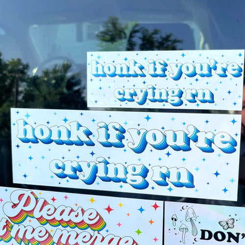 Mini and full-size Honk If You're Crying bumper stickers shown together on a car window for size comparison.
