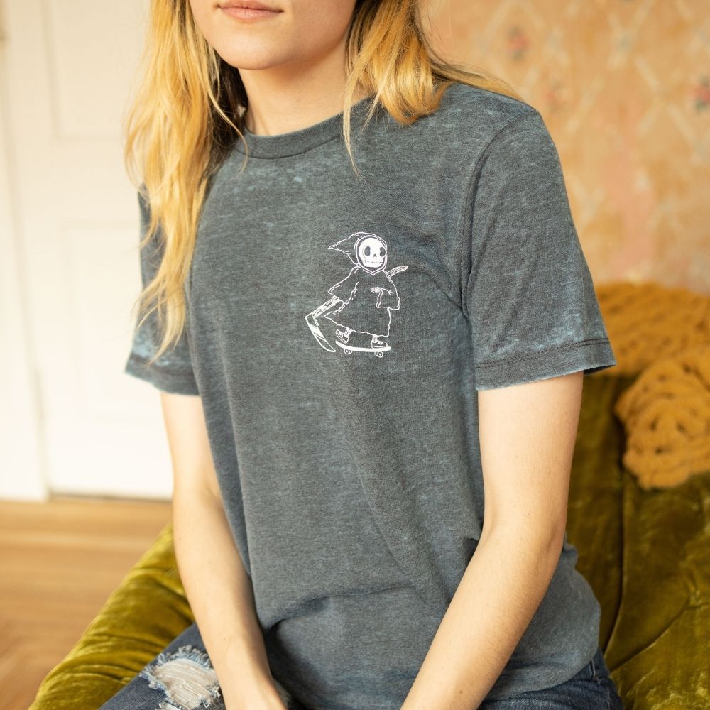 Front view of The Funnel Cake Tree’s charcoal heather burnout t-shirt featuring a small white Grim Reaper on a skateboard with a scythe and the text “Keep It Kind” on the chest.