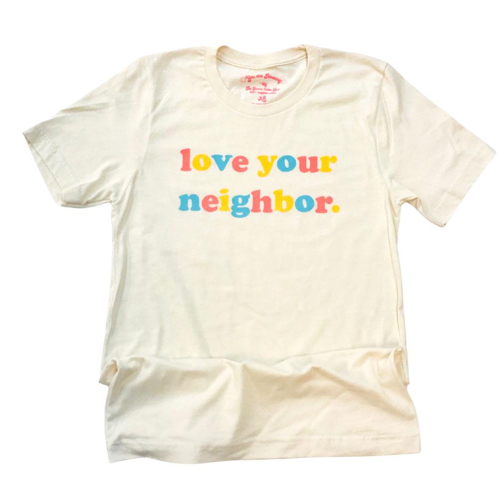Love Your Neighbor cream graphic t-shirt with colorful retro text in orange, yellow, and blue, flat lay on white background – positive message tee – The Funnel Cake Tree.