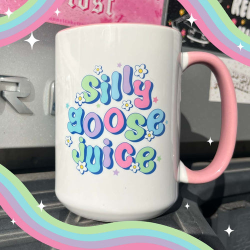 White ceramic mug with a pink handle featuring the text Silly Goose Juice in colorful bubble letters with small flowers.