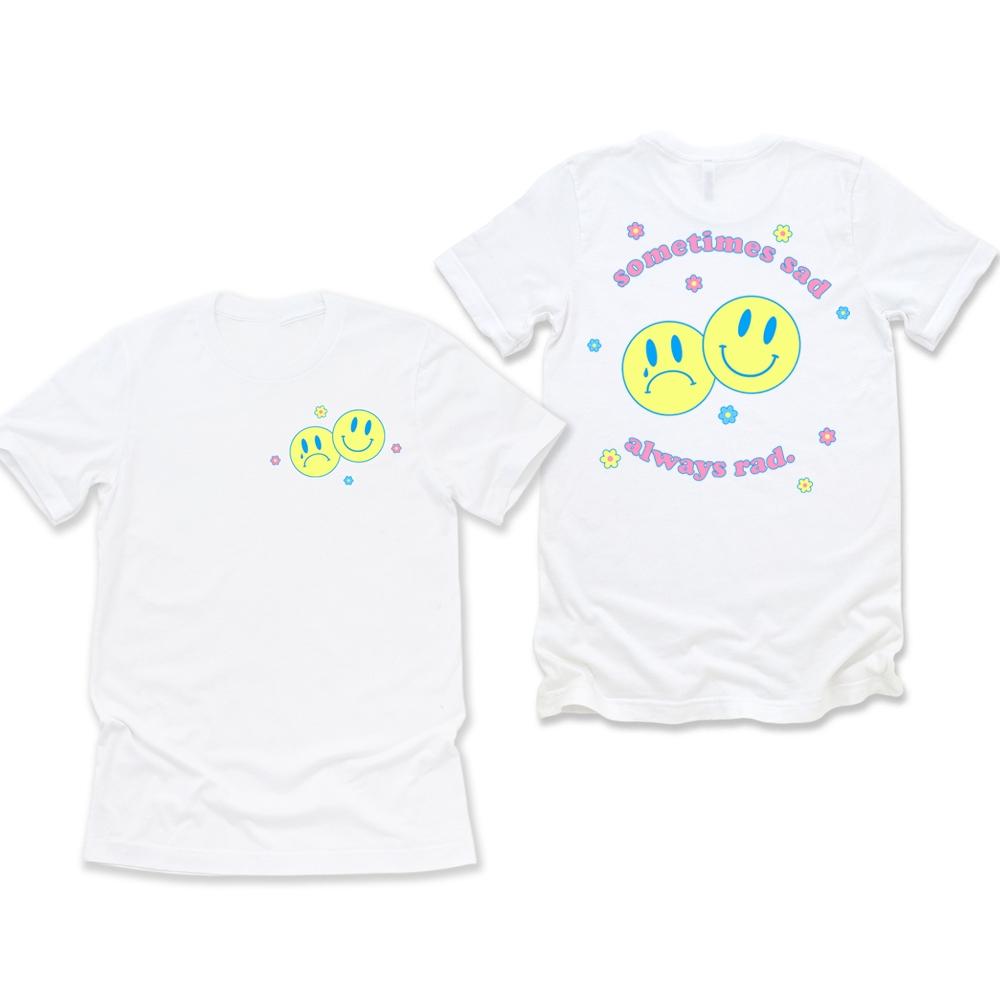 White graphic t-shirt with front and back prints featuring two yellow smiley faces and pastel flowers with text “Sometimes Sad Always Rad” – retro aesthetic tee – The Funnel Cake Tree.