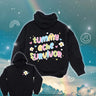 Black hoodie with colorful pastel text reading “tummy ache survivor” surrounded by hearts and flowers, and a small flower design on the front chest.