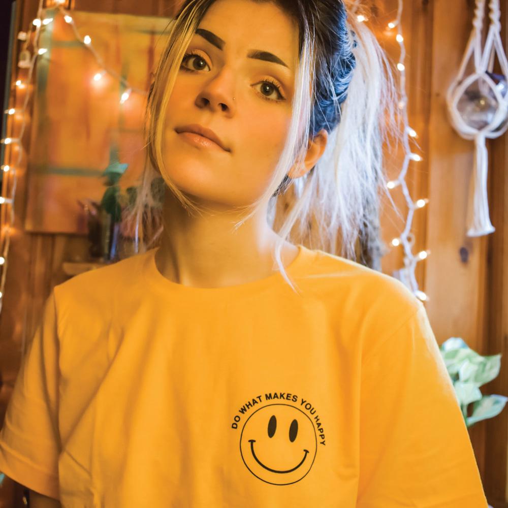 Yellow ‘Do What Makes You Happy’ t-shirt by Funnel Cake Tree featuring a black smiley face design, cheerful positive graphic tee.