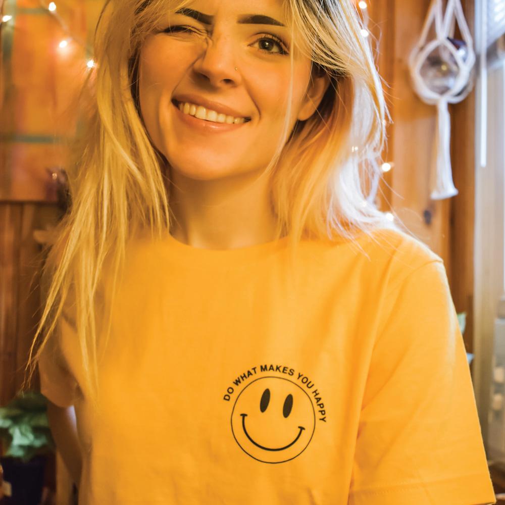 Yellow ‘Do What Makes You Happy’ graphic t-shirt by Funnel Cake Tree featuring a minimalist black smiley face design, positive and uplifting tee.