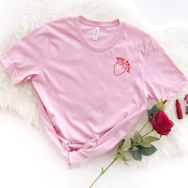 Light pink ‘Stay Sweet’ t-shirt by Funnel Cake Tree featuring a red strawberry graphic and playful positive message,  cute feminine graphic tee.